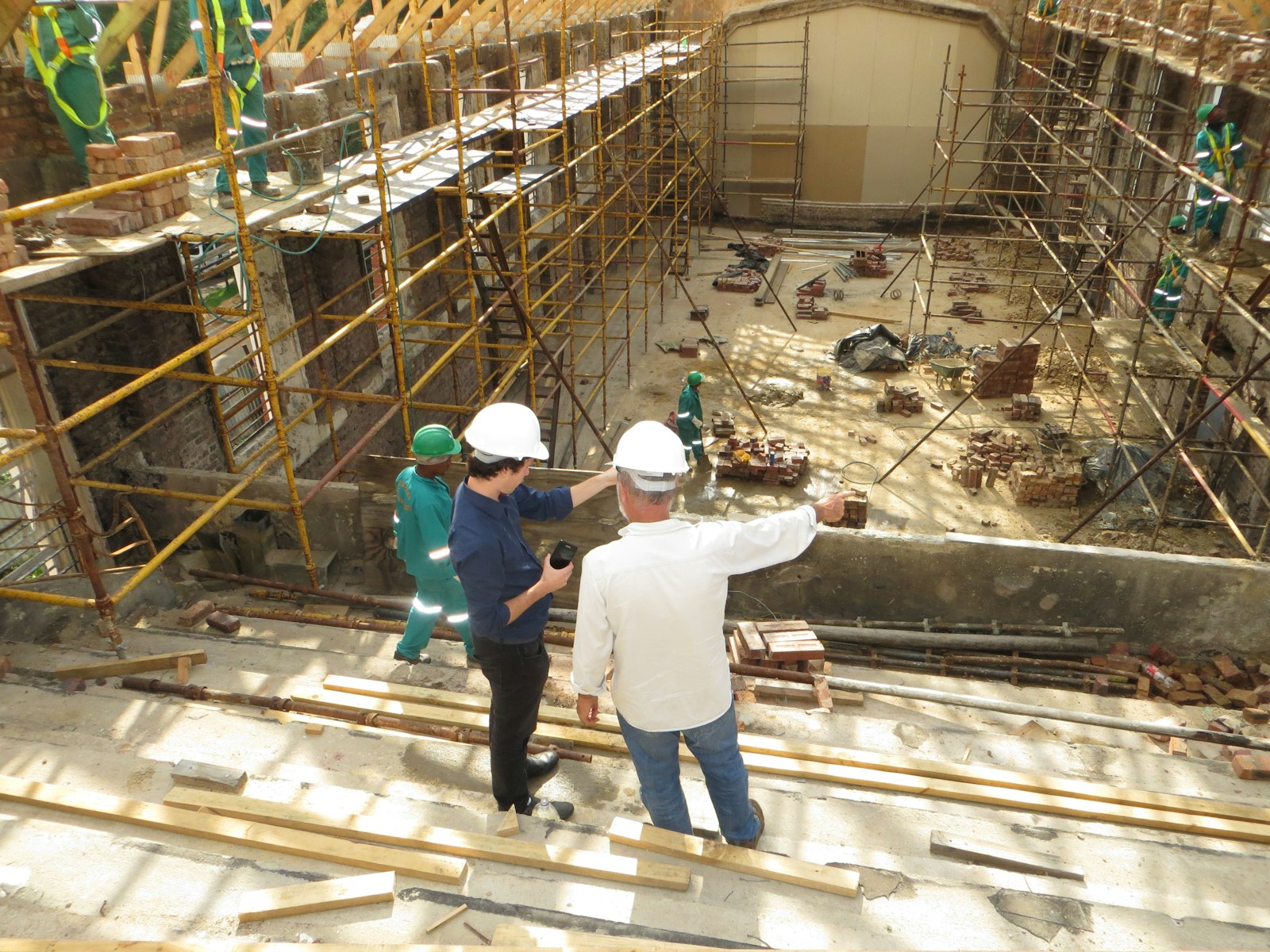 man in white long sleeve shirt and blue denim jeans standing on white metal ladder, construction